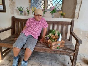 Person sitting on a bench with flowers