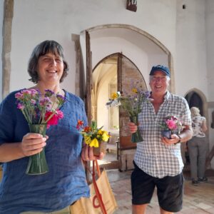 2 people holding cut flowers