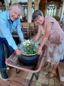 Flower pit being listed out of a wheel barrow